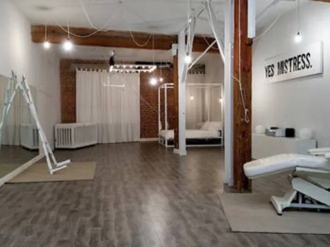 Créez une salle de BDSM à l'ambiance minimaliste et perverse avec ce concept en noir et blanc. Ce type de décor, épuré mais évocateur, est parfait pour un donjon BDSM fait maison où l'attention se porte sur les partenaires et les accessoires. L'inscription murale renforce l'atmosphère de soumission, une idée BDSM facile à reproduire pour une déco BDSM efficace. C'est un excellent exemple de comment obtenir une ambiance BDSM forte avec un mobilier BDSM simple, idéal pour un donjon maison ou une pièce BDSM dédiée qui mise que sur l'équipement lourd.