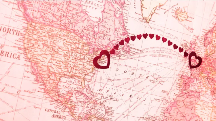 deux cœurs rouges connectés sur une carte du monde rose, relations à distance